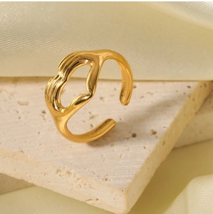 Detailed view of an adjustable golden hug ring on a stone stand with silk background