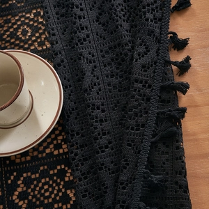 Vintage American style black crochet lace tablecloth with elegant fringe on wood table