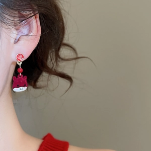 Macro view of Chinese New Year red flocked mascot earrings with lucky FU character charm