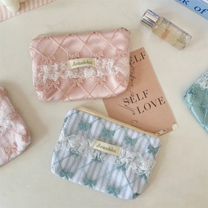 Detailed shot of lace floral coin purses with bow embroidery and metal zipper closure