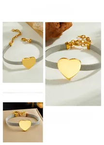 Detailed view of the gold heart pendant and adjustable silver mesh chain with lobster clasp