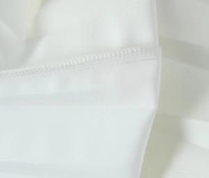Macro view of white fabric edge stitching and smooth texture on the women blazer and skirt