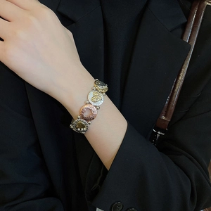 Detail view of tri-color heart metal bracelet with hammer texture and rhinestones on model