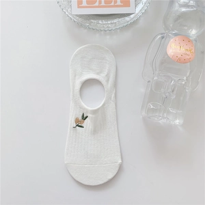 Detail of white cotton invisible sock featuring a delicate small plant embroidery