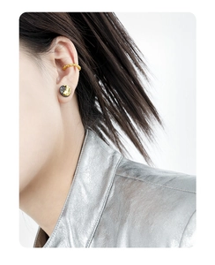 Close-up of lava texture S925 silver earrings and gold cuff on a model
