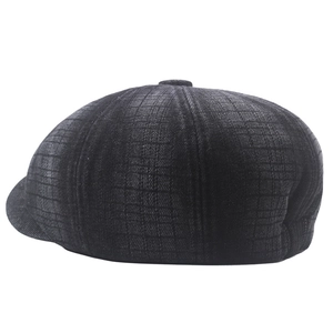 Detail view of dark grey newsboy cap showing textured plaid fabric and multi-panel stitching