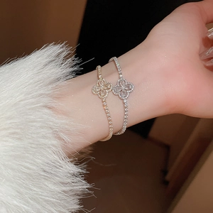 Détail de bracelets fleurs or et argent avec zircons au poignet et poignets en peluche