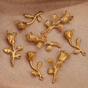 Macro shot of 18K gold-plated rose flower pendants on brown silk fabric background