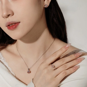 Detailed view of model wearing S925 sterling silver heart necklace, earrings and ring set