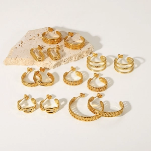 Collection of various 18K gold plated stainless steel hoop earrings on a stone detail view