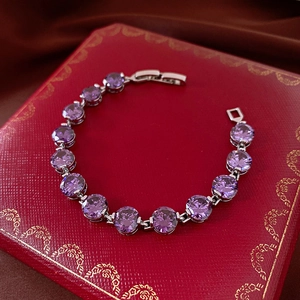 Macro shot of silver tennis bracelet with purple zircons on a luxury red jewelry box