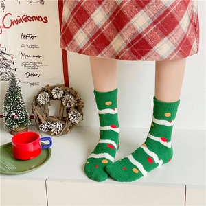Detailed view of green thick coral fleece socks with festive patterns for Christmas