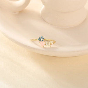 Macro shot of S925 silver gold ring with pink heart and colorful enamel flowers