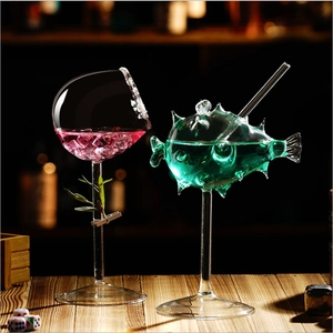 Creative octopus and puffer fish shaped cocktail glasses on a dark wooden bar counter