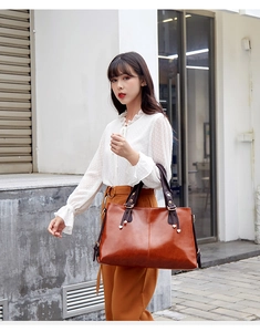 Large capacity brown leather tote bag detail shot, stylish commuter handbag with contrast design.