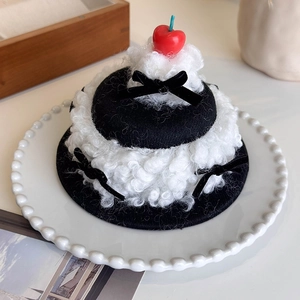 Detailed view of creative cherry cream cake hat hair clip on a white pearl ceramic plate