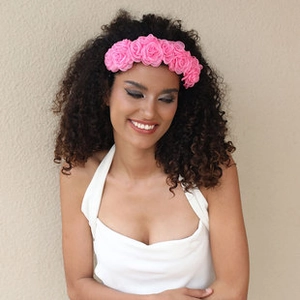 Close-up of a pink handmade fabric floral headband with realistic roses on a female model