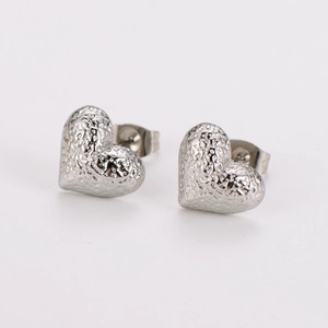 Macro shot of silver stainless steel heart stud earrings with hammered metal texture