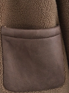 Detail of brown fleece jacket showing contrast faux leather pocket and stitching