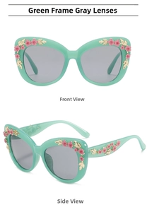 Detail view of mint green cat-eye sunglasses with pink enamel flowers and gold floral patterns