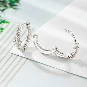 Elegant silver star-shaped hoop earrings with sparkling cubic zirconia on a minimalist leaf