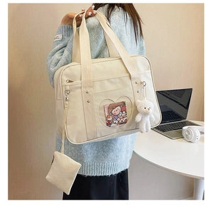 Detail of JK style ita bag in cream white with heart window and cute plush bear charm