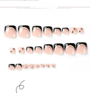 Detail of black French toenail tips with gold glitter lines and star patterns