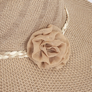 Detailed macro view of woven raffia sun hat texture with elegant chiffon flower decoration