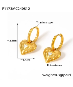 Detail of 18k gold plated heart earrings with rhinestones and hammered texture