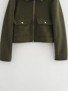 Détail de la veste en tweed vert foncé avec de grandes poches plaquées et fermeture éclair