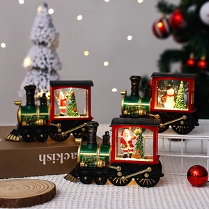 Close-up of lit Christmas train ornaments with Santa and snowman inside water cab