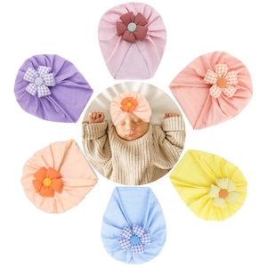 Collage of colorful infant turbans featuring 3D fabric flowers and soft pastel shades