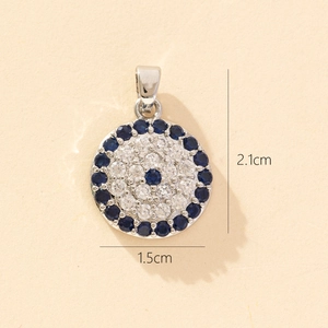 Macro view of silver evil eye pendant featuring deep blue and clear zircon stones