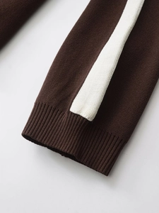 Detailed macro shot of dark brown knit cuffs with white side stripes and ribbed texture