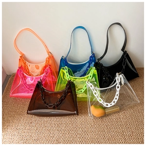 Close-up of colorful transparent PVC shoulder bags with decorative plastic chains and zipper