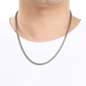 Gros plan d'un collier chaîne minimaliste pour homme en acier inoxydable argenté porté