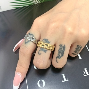 Detail of twisted curb chain ring in gold and silver finish worn by a model