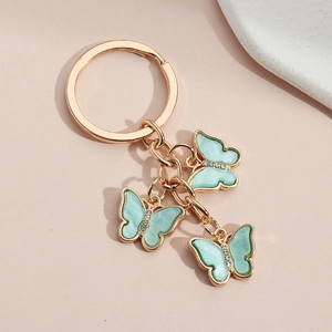 Golden keychain with three light blue acrylic butterfly pendants and sparkly rhinestones