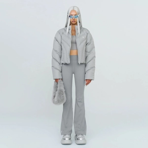 Women's grey high-waisted flared trousers paired with a cropped puffer jacket and plush bag