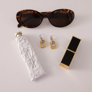 Macro detail of interlocking gold and silver geometric steel earrings on stylish vanity