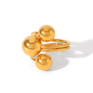 Macro detail of three polished gold spheres on a multi-layer stainless steel ring