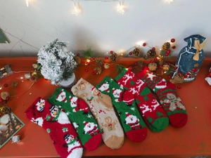 Close-up of assorted festive coral fleece Christmas socks with holiday decorations