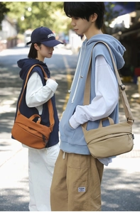 Outdoor shot of khaki and orange crossbody bags showing adjustable straps and nylon texture