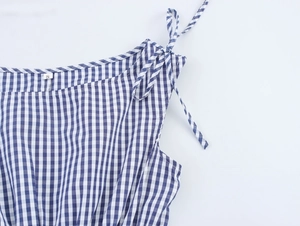 Detail of blue plaid dress showing shoulder tie-up bow and size S label texture