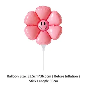 Pink daisy flower balloon with smiling face showing measurements and white holding stick