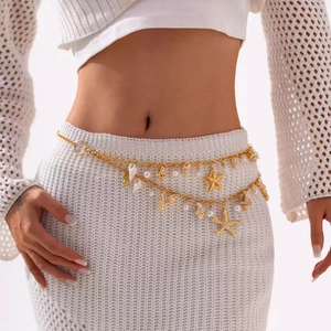 Close-up of golden starfish and pearl charms on a double-layer waist chain jewelry