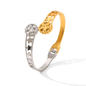Detail of two-tone gold and silver open bangle with star cutouts and floral ends