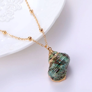 Elegant gold bead chain necklace with natural green seashell pendant on white background
