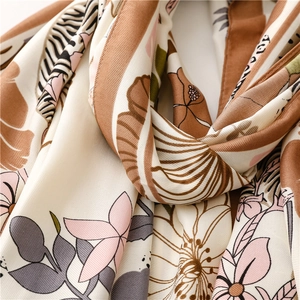 Detailed view of silk scarf fabric showing tropical flower patterns and twill texture