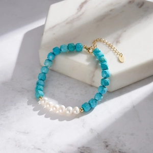 Detail of turquoise and pearl beaded bracelet with 14K gold lobster clasp and chain